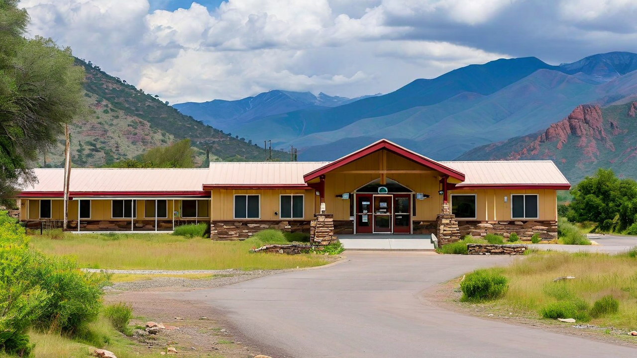 Rural clinic exterior with mountain backdrop, patient arriving